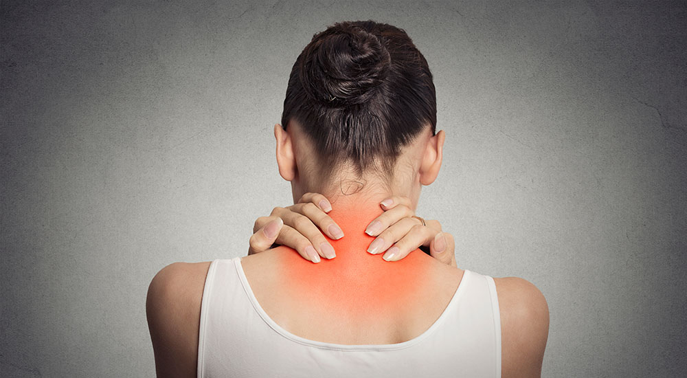Healthy lifestyle. Back and spine disease. Closeup back view tired female massaging her neck colored in red isolated on gray background